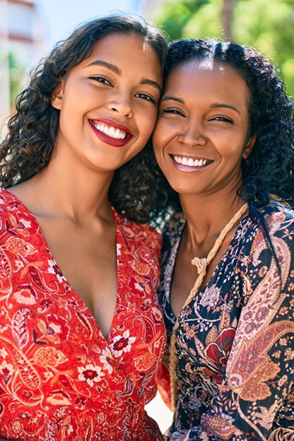 African american mother and daughter smiling happy hugging at the park.