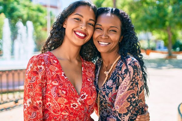 African american mother and daughter smiling happy hugging at the park.